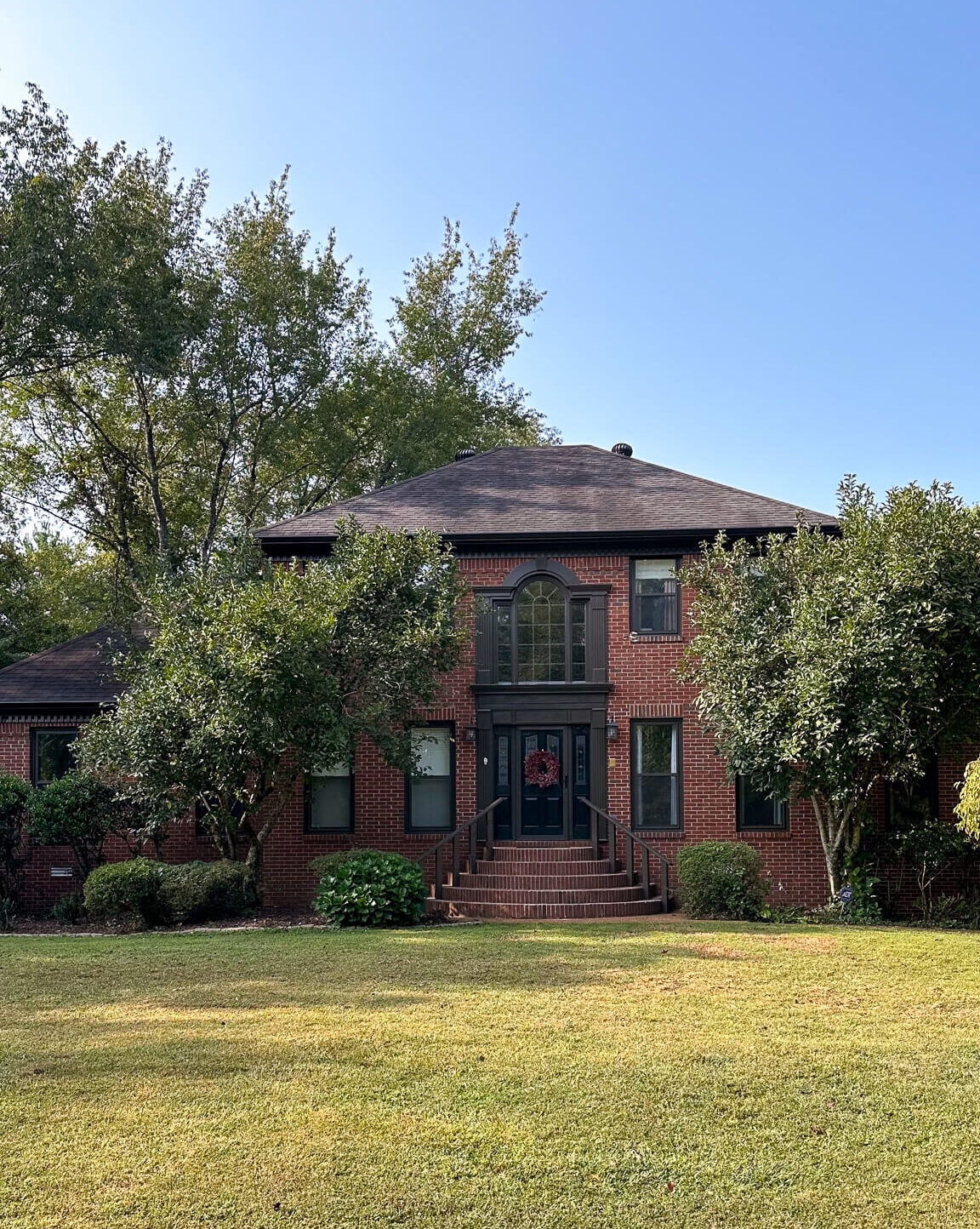 moody-exterior-makeover-dark-grey-black-trim-red-brick-house