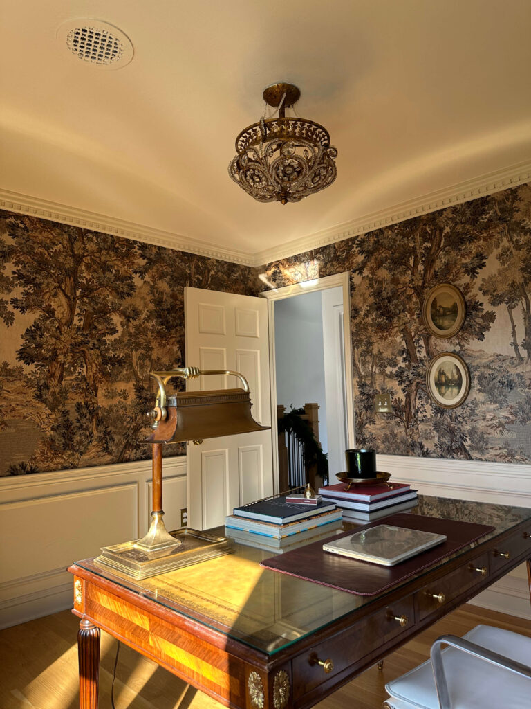 Vintage moody traditional home office with landscape mural, antique desk and vintage lamp