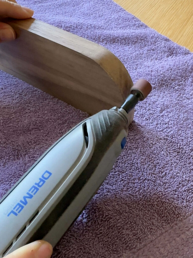 using my dremel tool with sanding attachment to smooth out my diy spice rack arches