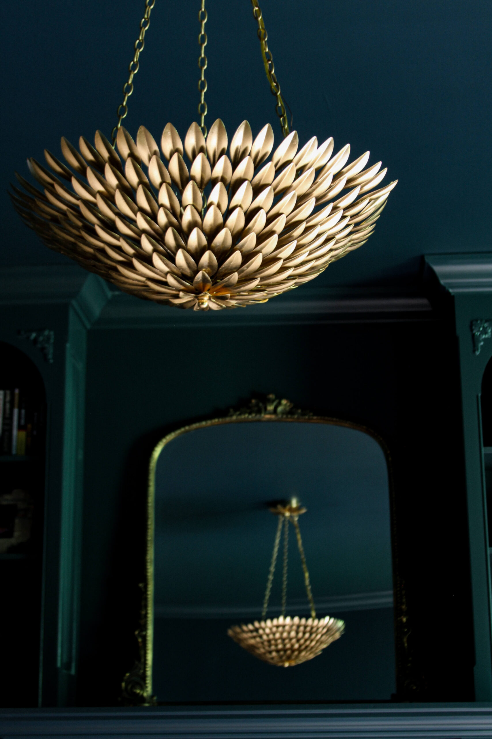 gold leaf chandelier reflected in primrose mirror