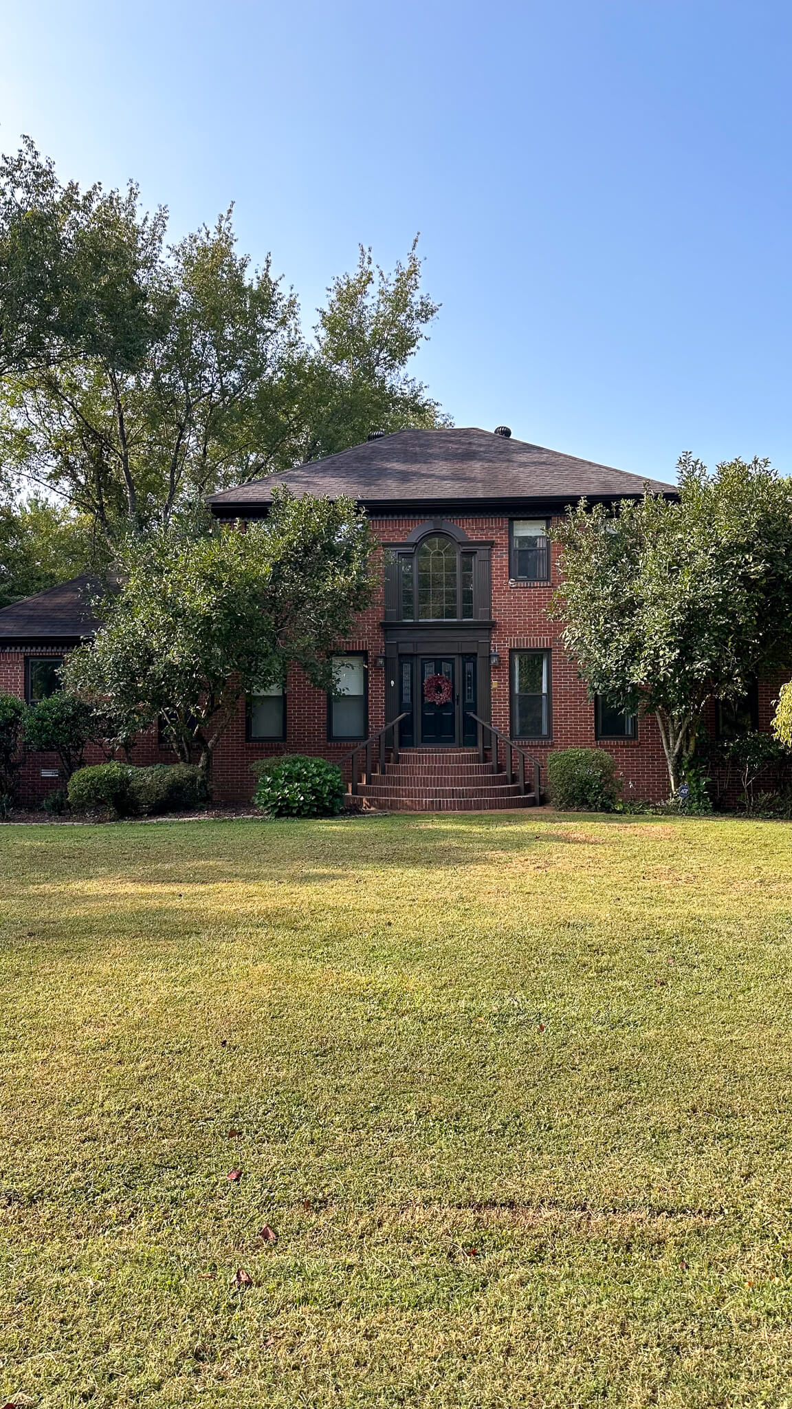 moody-exterior-makeover-dark-grey-black-trim-red-brick-house