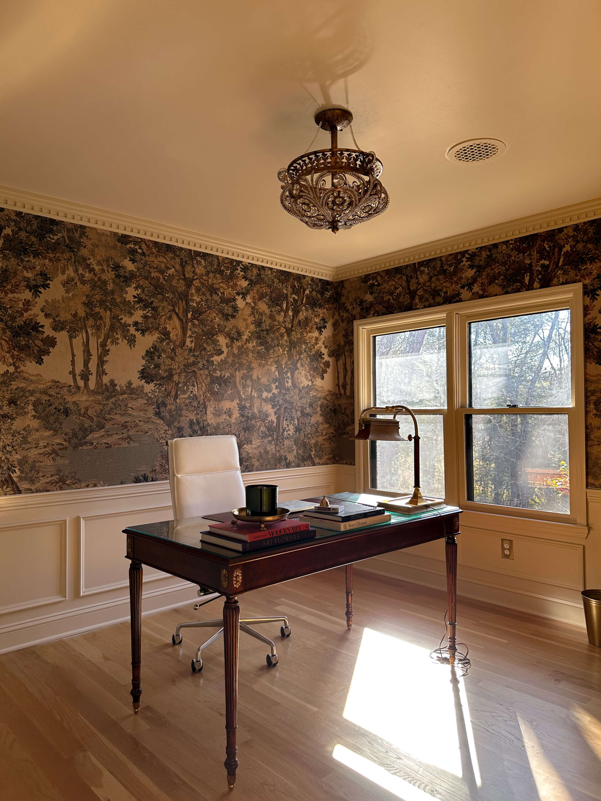 click to read about the Vintage moody traditional home office reveal. The design includes a landscape mural, antique desk and vintage lamp.